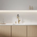 Jasna kuchnia z białym blatem, drewnianymi frontami, zlewozmywakiem, baterią kuchenną Omnires VITA z wyciąganą wylewką kolor złoty połysk/czarny mat VI6350BLGL