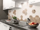 Kuchnia z białymi szafkami, ciemnym marmurowym blatem oraz dekoracyjną mozaiką ścienną w kształcie białego i drewnianego heksagonu Ceramik Studio Heksagon White-Wood 36x25