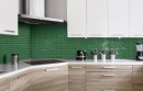 Kuchnia z drewnianymi i białymi frontami szafek, białym blatem, stalowym okapem oraz zieloną mozaiką ścienną w połysku w kształcie cegiełek Ceramik Studio Modena Emerald 30,8x30,3