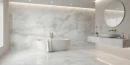Netto Ceramika Onyx Grey Matt 60x120 szara płytka imitująca marmur wykończona w macie położona na podłodze w łazience gdzie znajduje się duża wanna oraz okrągłe wiszące lustro