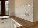Dekoracyjne płytki ceramiczne na ścianie nad drewnianym blatem kuchennym, w połysku, biała, kształt arabeski Ceramik Studio Arabeska White Palace Glossy 12,5x14,5
