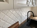 Dekoracyjne płytki ceramiczne na ścianie nad drewnianym blatem kuchennym, w połysku, biała, kształt arabeski Ceramik Studio Arabeska White Palace Glossy 12,5x14,5