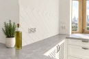 Dekoracyjna matowa płytka ścienna biała arabeska Ceramik Studio Arabeska White Palace Mat 12,5x14,5 ułożona nad szarym marmurowym blatem
