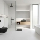 Łazienka z białymi, antypoślizgowymi płytkami imitującymi beton Cifre Acron White Mate Antislip 120x120, z czarną, matową armaturą, podwieszaną szafką podumywalkową w kolorze drewna , kabiną walk-in z przeszkloną ścianką, wolnostojącą, białą wanną.