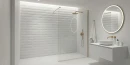 Biała łazienka z płytkami ściennymi, imitującymi beton Cifre Acron Exact White Mate Xs Pb Rect. 30x60, z kabiną typu walk-in, złotą szczotkowaną armaturą, okrągłym podświetlanym lustrem led, białą podwieszaną szafką.