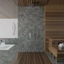 Nowoczesna strefa SPA i prysznic wyłożone grafitowymi płytkami WOW Marble Graphite R11 11x11 cm (132926) imitującymi marmur. Ściana z deszczownicą połączona z drewnianymi lamelami, w tle basen oraz ławki ze świeżymi ręcznikami.