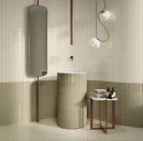 Elegancka łazienka z beżowymi płytkami WOW Micare Linen Light Gloss 5x15 cm (139762) ułożonymi pionowo na ścianie. Wnętrze z wolnostojącą umywalką, owalnym lustrem na stelażu, designerską lampą i stolikiem.
