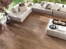 Taras z jasnymi meblami wypoczynkowymi i płytkami drewnopodobnymi Porcelanosa Manhattan Cognac