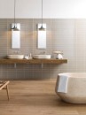 Łazienka z wanną wolnostojącą, umywalkami nablatowymi, drewnianym blatem i beżowymi płytkami ściennymi Porcelanosa Malaga Beige L 25x44,3 100322664