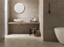 Łazienka z białą wanną wolnostojącą, białą umywalką nablatową, dekoracyjnymi płytkami na ścianie Porcelanosa Cubik Urban Caliza oraz beżowymi na podłodze Urban Caliza Nature