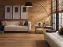 Salon z białą sofą i z płytkami drewnopodobnymi Porcelanosa Nobu Roble