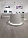 Wnętrze sklepu z szarymi płytkami podłogowymi drewnopodobnymi Porcelanosa Minnesota Ash